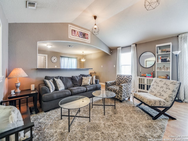 living room with light hardwood / wood-style flooring and vaulted ceiling