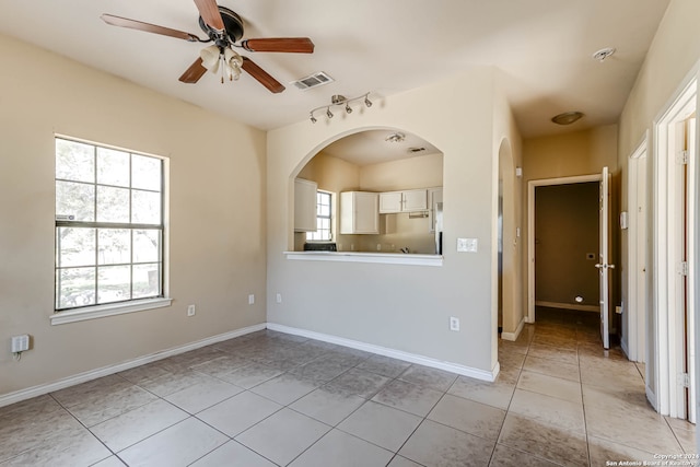 tiled empty room featuring ceiling fan