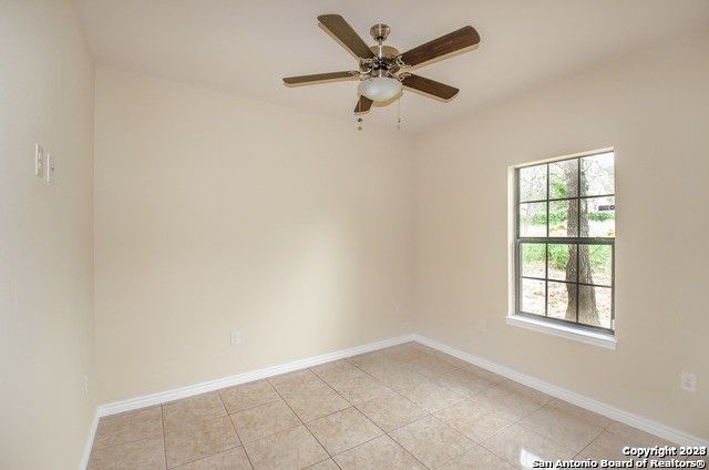 tiled empty room with ceiling fan