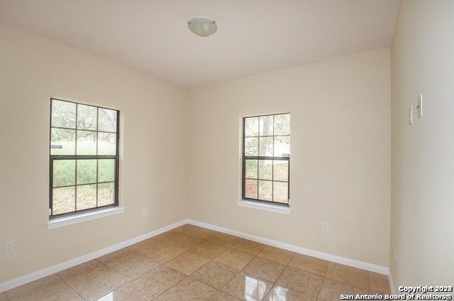 spare room featuring light tile patterned floors and plenty of natural light