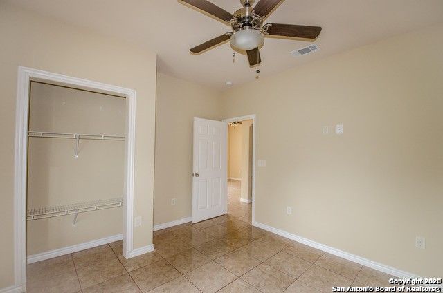 unfurnished bedroom featuring a closet, ceiling fan, and light tile patterned floors