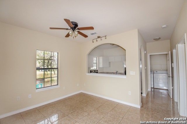 tiled spare room with ceiling fan and independent washer and dryer