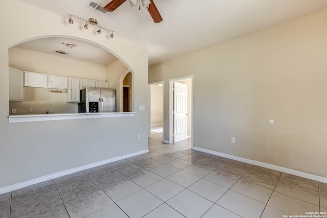 empty room with ceiling fan and light tile patterned floors