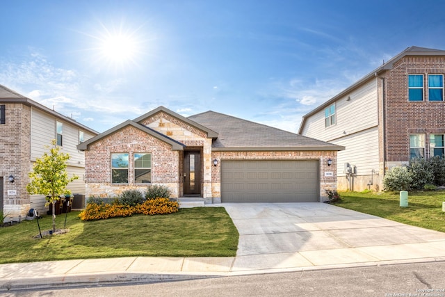 view of front of house with a front yard, central air condition unit, and a garage