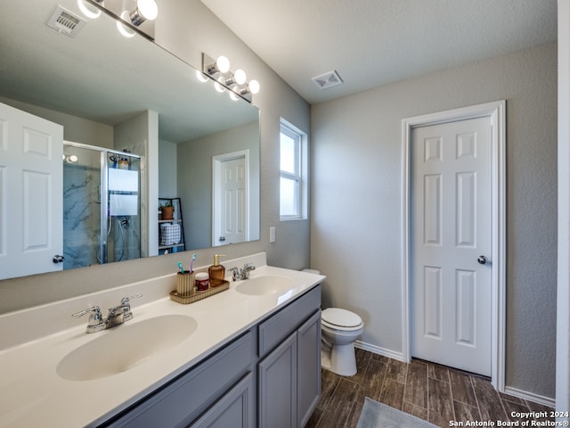 bathroom with toilet, walk in shower, and vanity