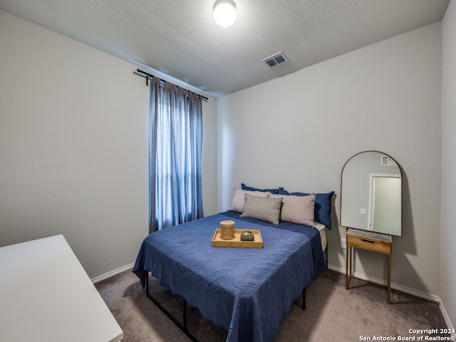 carpeted bedroom featuring a textured ceiling