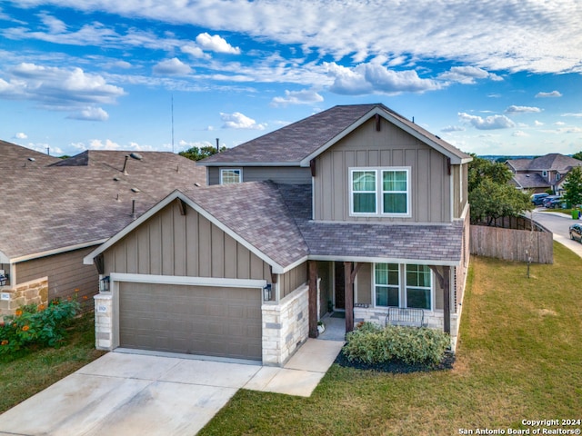 craftsman-style house featuring a front yard, covered porch, and a garage