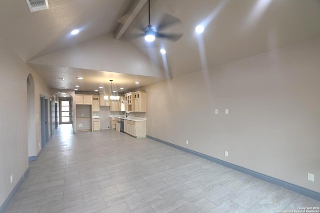 unfurnished living room with ceiling fan with notable chandelier, beamed ceiling, high vaulted ceiling, and sink