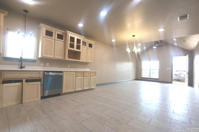 kitchen featuring lofted ceiling, hanging light fixtures, stainless steel dishwasher, cream cabinetry, and an inviting chandelier