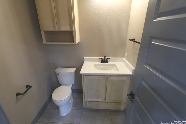 bathroom featuring tile patterned flooring, vanity, and toilet