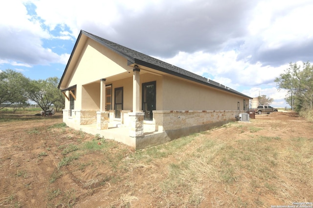 rear view of property with cooling unit and a patio