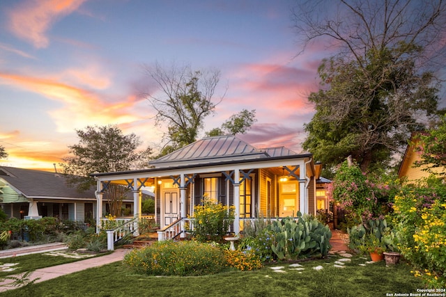 view of front of house featuring a lawn and covered porch