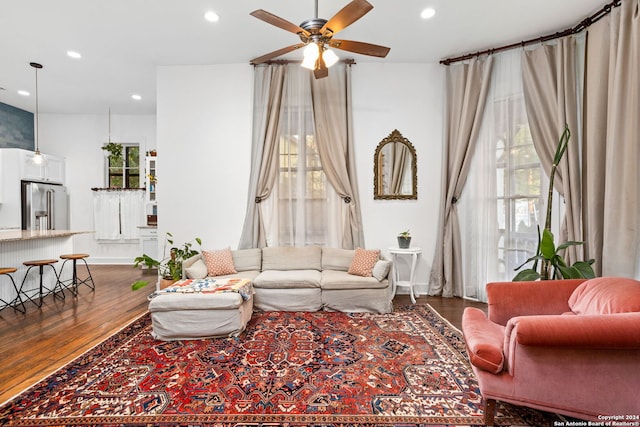 living room featuring ceiling fan and dark hardwood / wood-style flooring