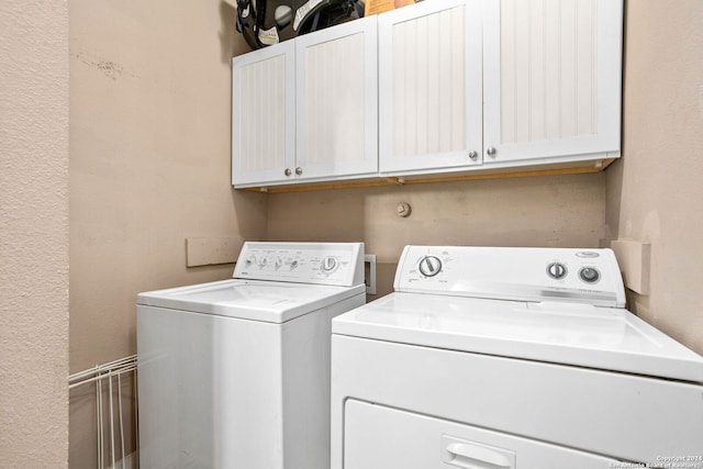 clothes washing area featuring cabinets and independent washer and dryer