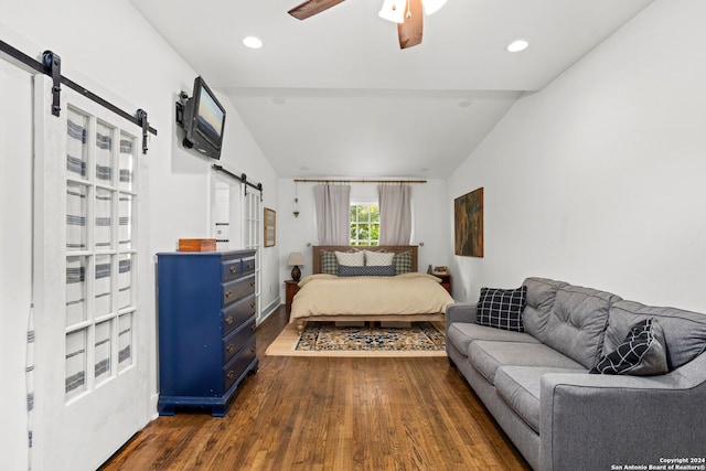 bedroom featuring a barn door, vaulted ceiling, ceiling fan, and dark wood-type flooring