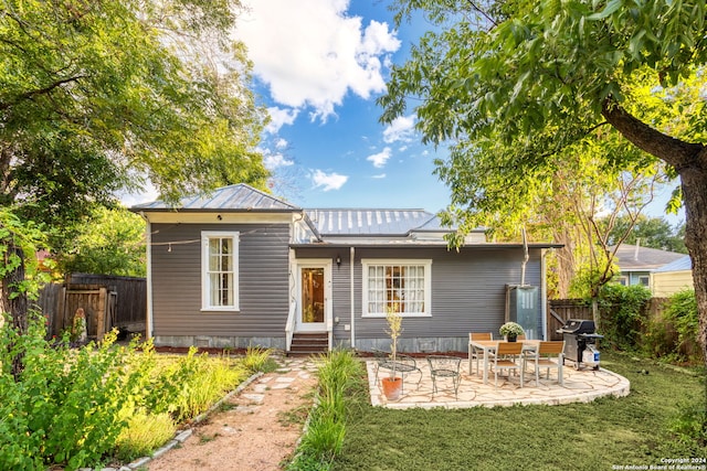 rear view of house featuring a yard and a patio