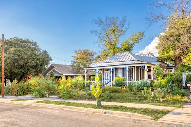 bungalow-style home with a front yard and covered porch