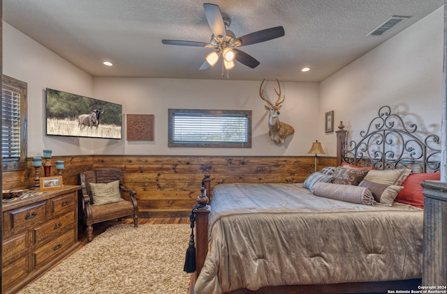 bedroom featuring ceiling fan, a textured ceiling, and hardwood / wood-style floors