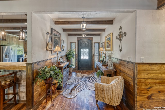 foyer featuring wood-type flooring and beam ceiling