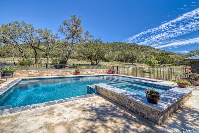 view of swimming pool with an in ground hot tub and a patio area