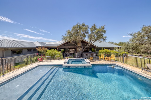 view of swimming pool with a patio and an in ground hot tub