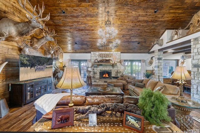 living room featuring an inviting chandelier, wood ceiling, hardwood / wood-style flooring, and a stone fireplace