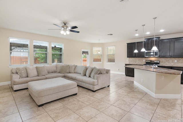 tiled living room featuring ceiling fan and sink