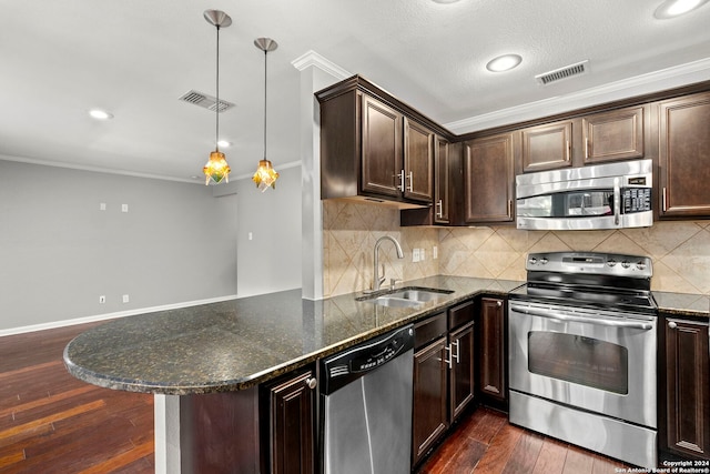 kitchen with sink, kitchen peninsula, stainless steel appliances, dark hardwood / wood-style flooring, and ornamental molding