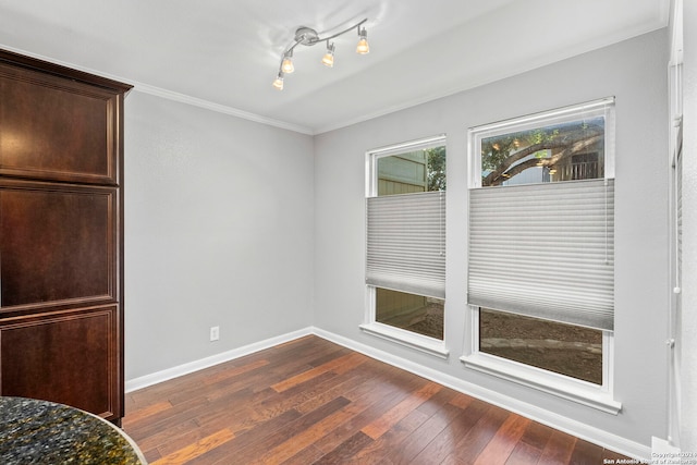 unfurnished dining area with ornamental molding and dark hardwood / wood-style floors