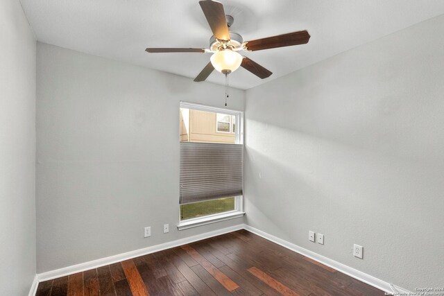 unfurnished room with a ceiling fan, dark wood finished floors, and baseboards