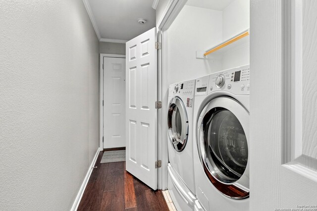 laundry area with dark wood finished floors, laundry area, baseboards, washer and clothes dryer, and crown molding