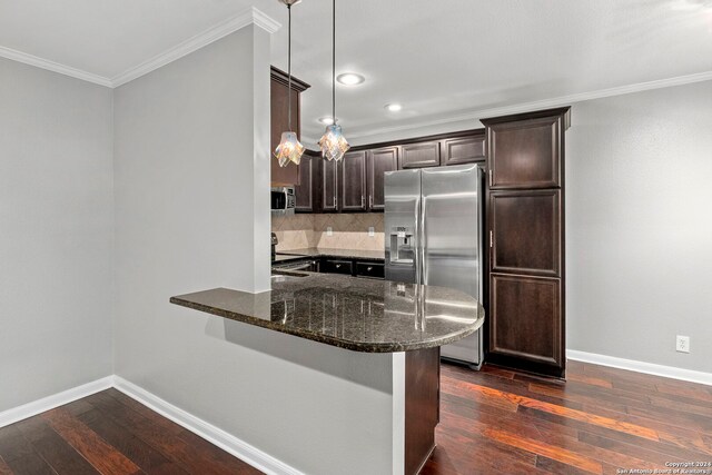 kitchen featuring dark stone countertops, appliances with stainless steel finishes, dark brown cabinets, ornamental molding, and dark wood-style floors
