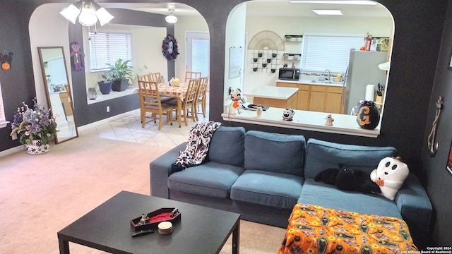 carpeted living room with sink and ceiling fan