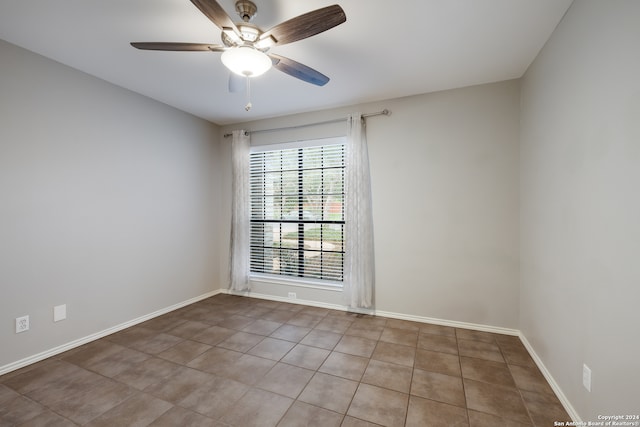 empty room featuring tile patterned flooring and ceiling fan