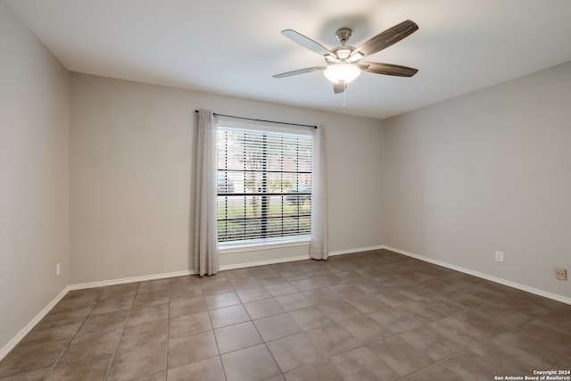 empty room with light tile patterned floors and ceiling fan