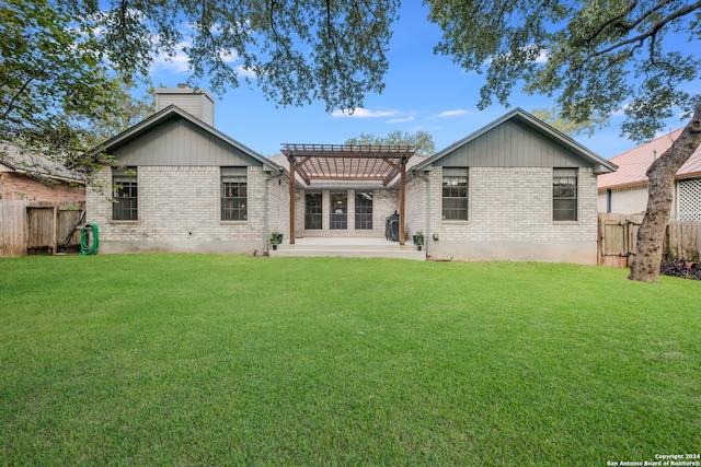 back of property with a pergola, a patio area, and a yard