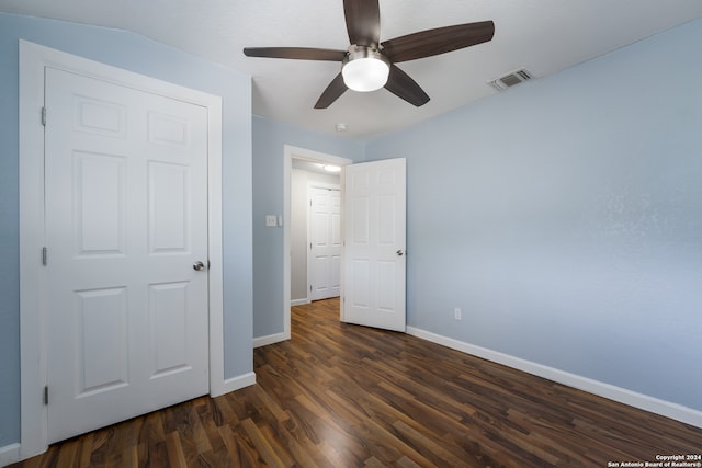 unfurnished bedroom with ceiling fan, a closet, and dark hardwood / wood-style floors