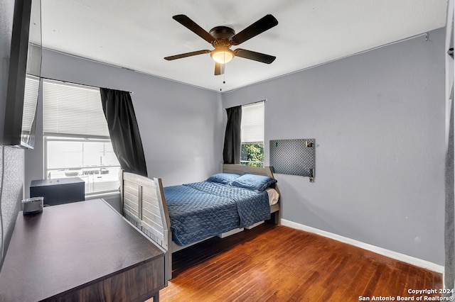 bedroom featuring multiple windows, ceiling fan, and hardwood / wood-style flooring