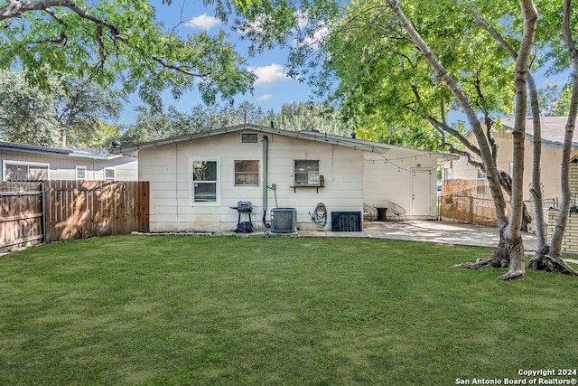 back of house with a lawn, central AC, and a patio area