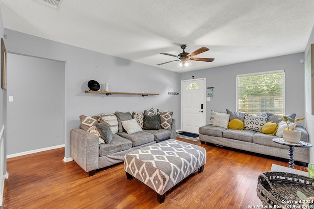 living room featuring ceiling fan, a textured ceiling, and hardwood / wood-style floors