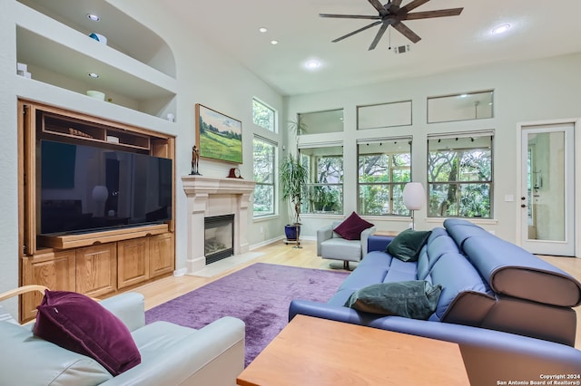 living room with a wealth of natural light, light hardwood / wood-style floors, and ceiling fan