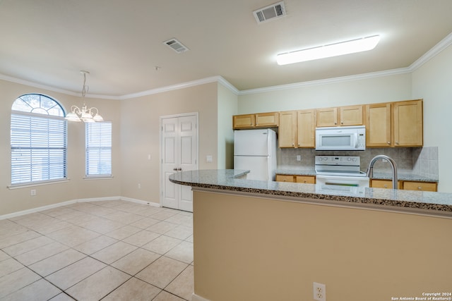 kitchen featuring a notable chandelier, dark stone counters, ornamental molding, and white appliances