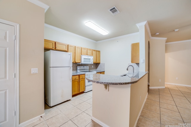 kitchen featuring white appliances, light tile patterned floors, a kitchen bar, and tasteful backsplash