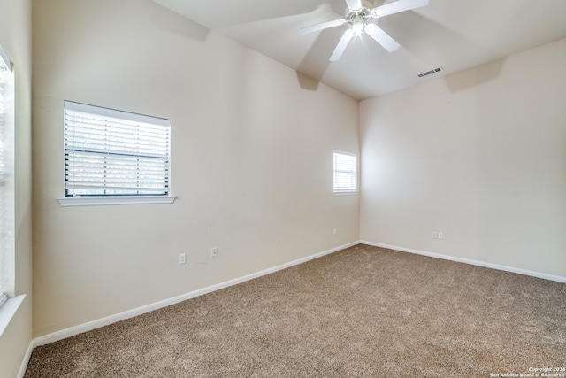 carpeted spare room with ceiling fan and plenty of natural light