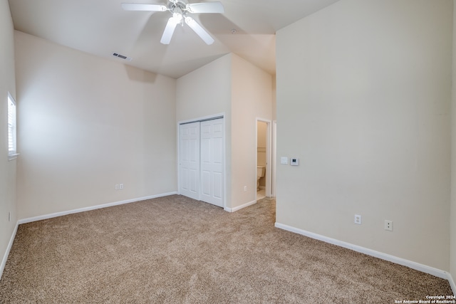 interior space featuring a closet, vaulted ceiling, ceiling fan, and light colored carpet