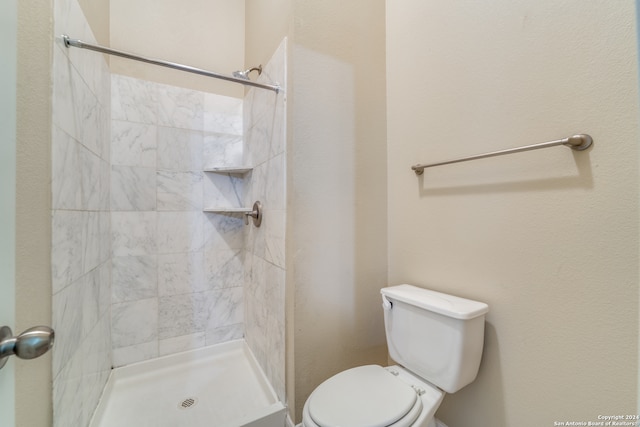 bathroom featuring toilet and a tile shower