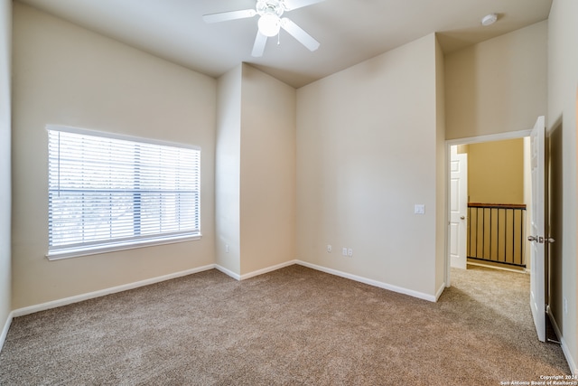 unfurnished room featuring ceiling fan and light carpet