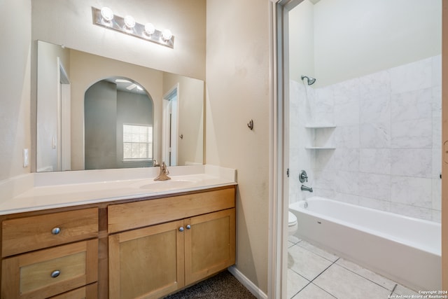 full bathroom featuring tile patterned flooring, tiled shower / bath, vanity, and toilet