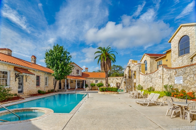 view of pool with a patio and a hot tub