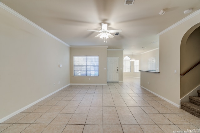 tiled empty room with ceiling fan with notable chandelier and ornamental molding